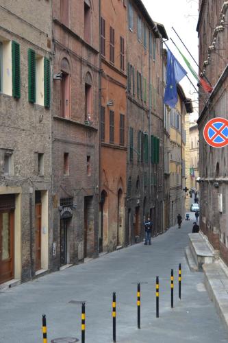 an alley with yellow and black poles in the street at B&B Quattro Cantoni in Siena