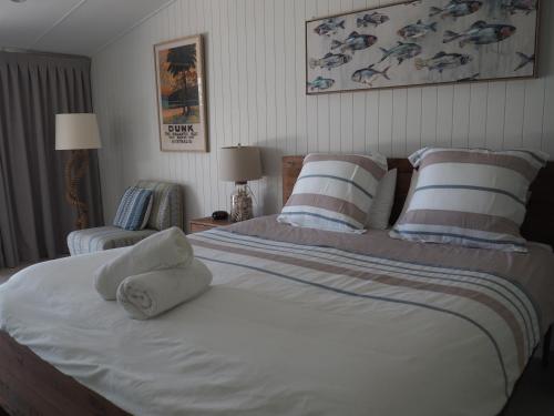 - une chambre avec un grand lit et des serviettes dans l'établissement Solace, à South Mission Beach