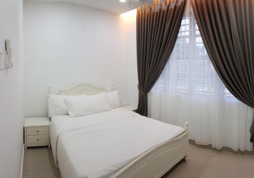 um quarto com uma cama branca e uma grande janela em D'Bangi Villa em Kampong Sungai Ramal Dalam
