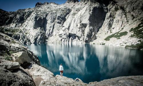 a man standing on a rock in front of a lake at stop saint pancrace in Corte