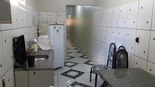 La cuisine est équipée d'un réfrigérateur et d'un évier. dans l'établissement Casa de Charles, à Piranhas