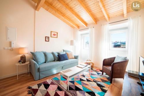 a living room with a blue couch and a table at Lis Apartments in Lisbon