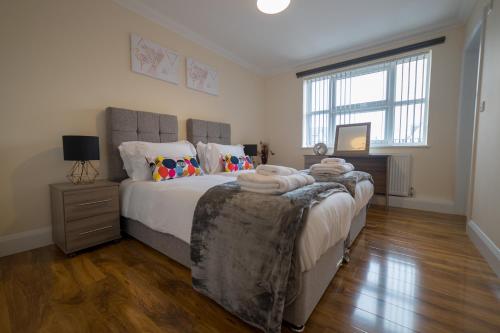 een slaapkamer met een groot bed en handdoeken bij London Heathrow Serviced Apartments in Stanwell