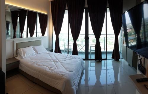 a bedroom with a bed and large windows at EVO SOHO STUDIO Suites in Kampong Sungai Ramal Dalam