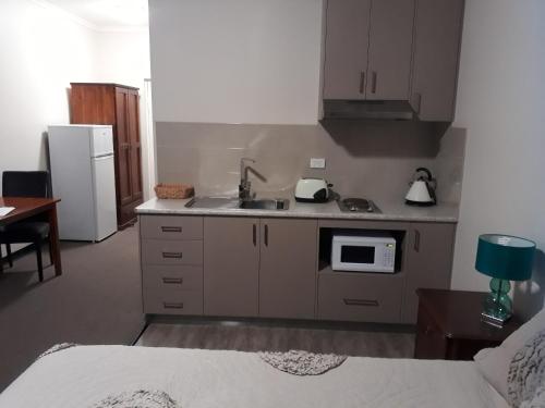 a kitchen with white cabinets and white appliances at Moe Motor Inn - Contactless 24 hour Checkinn Available in Moe