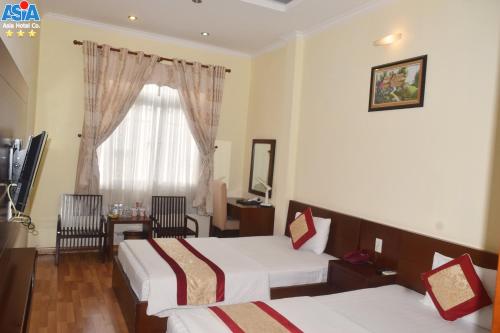 a hotel room with two beds and a window at Asia Hotel Can Tho in Can Tho