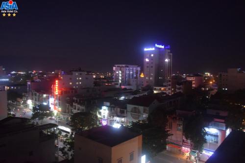a city lit up at night with buildings at Asia Hotel Can Tho in Can Tho