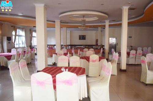 a banquet hall with white chairs and a table at Asia Hotel Can Tho in Can Tho
