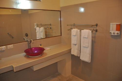 a bathroom with a sink and a mirror and towels at Mountain Lodge CheTica in San Jerónimo