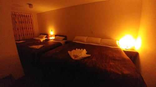 a hotel room with two beds and two lamps at Hostal El Peregrino in Cusco