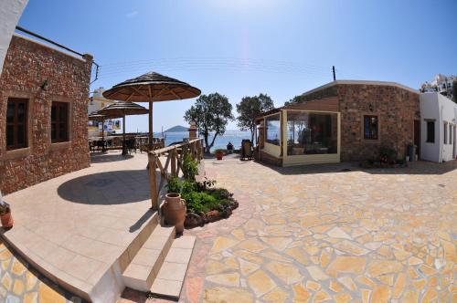 a patio with a building and an umbrella at Panteli Beach Hotel in Panteli
