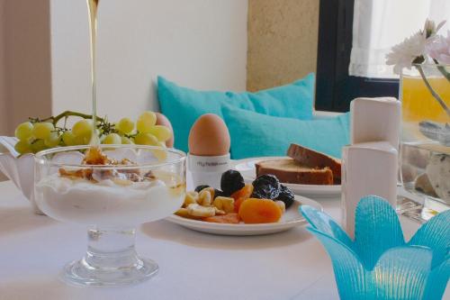 a table with a bowl of food and a plate of fruit at Mare Vista Hotel - Epaminondas in Batsi