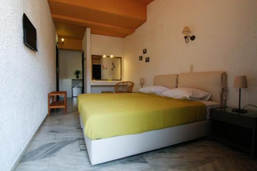 a bedroom with a yellow bed in a room at Mare Vista Hotel - Epaminondas in Batsi