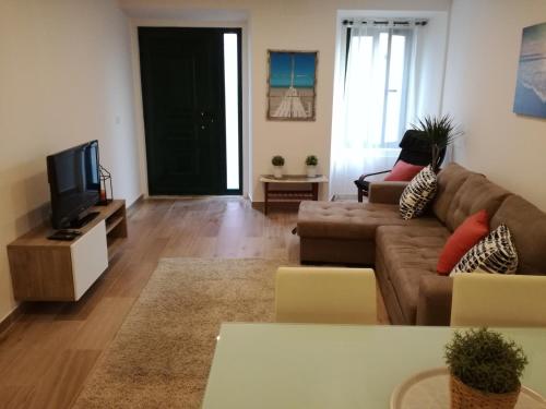 a living room with a couch and a tv at Sonetos do Sado in Setúbal