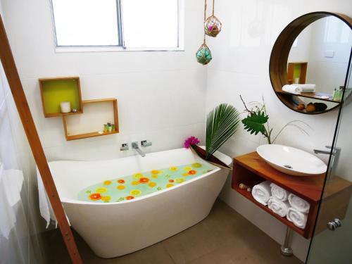 Villa Marine Holiday Apartments Cairns في Yorkeys Knob: حمام أبيض مع حوض ومغسلة
