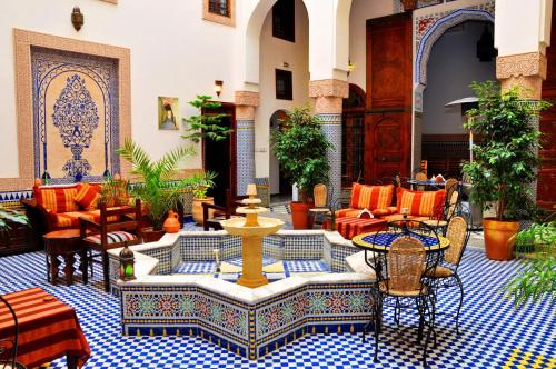 a courtyard with a fountain in a building at Riad Ahlam in Fès