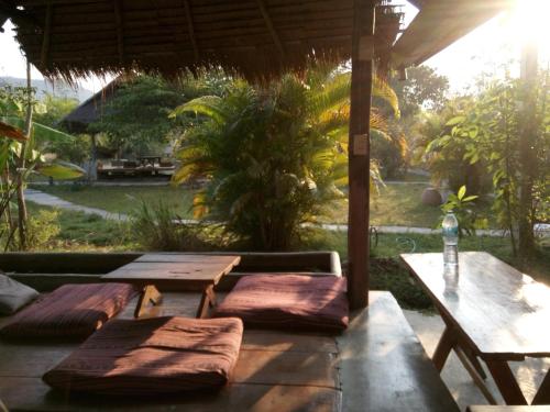 a patio with picnic tables and a table with a bottle of water at Ing Doi Guest House in Pai
