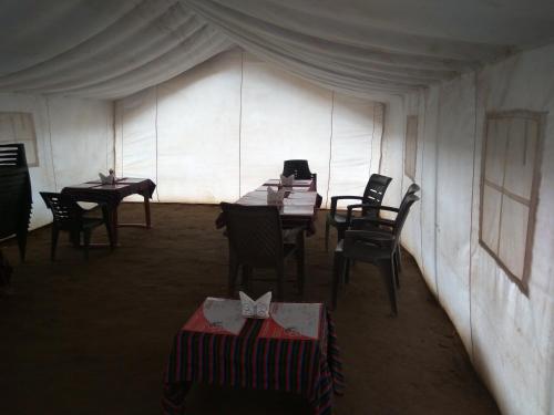 una habitación con mesas y sillas en una tienda de campaña en Garjha Hill Sight Trekking & Camping, en Sir Bhum Chun