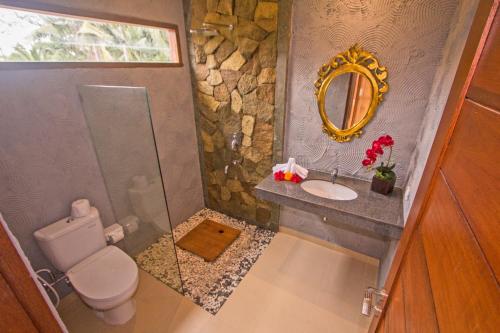 a bathroom with a toilet and a sink and a mirror at Ratna Villa 4 in Ubud