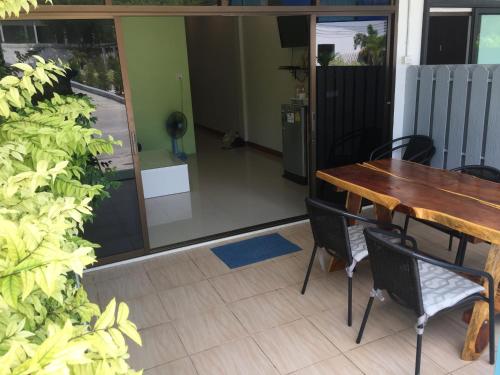 a dining room with a wooden table and chairs at Baan AomSub in Ko Samed