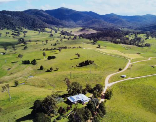 an aerial view of a house in a field with a road at The Old School Bed and Breakfast in Wolumla South