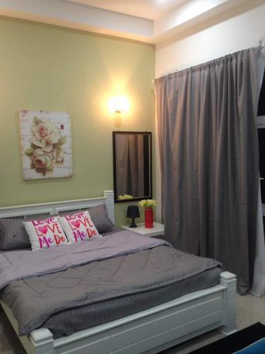 a bedroom with a large bed with pink pillows at Julia's Cottage in Kota Bharu