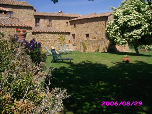 a yard with a bench in front of a building at Villa Fonte all'Oppio con area piscina recintata in Pienza