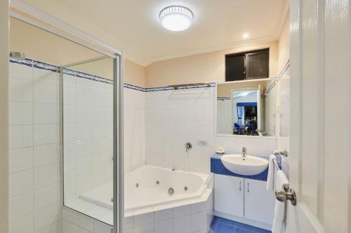 a bathroom with a tub and a sink and a shower at BIG4 Breeze Holiday Parks - Busselton in Busselton