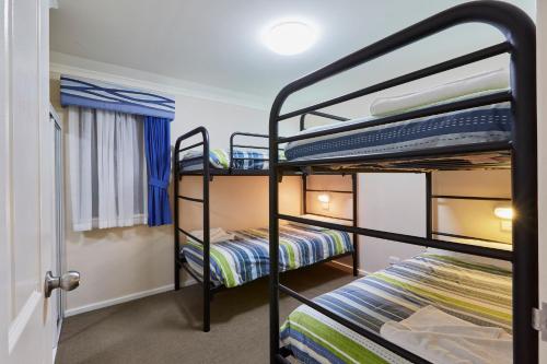 a bedroom with two bunk beds in a room at BIG4 Breeze Holiday Parks - Busselton in Busselton