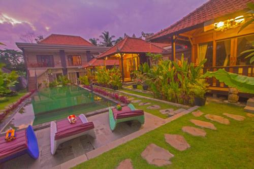 a house with a garden with benches in front of it at Ratna Villa 4 in Ubud