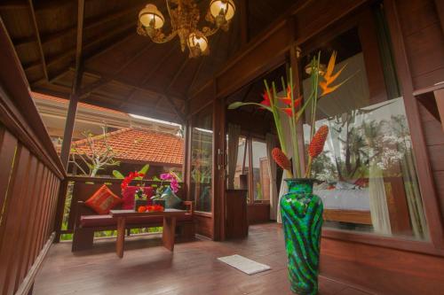 a green vase with flowers in the middle of a room at Ratna Villa 4 in Ubud