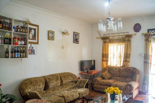 uma sala de estar com um sofá e uma cadeira em Efraz Motel Kanungu em Kinkizi