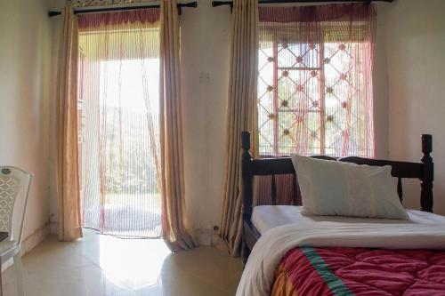 A bed or beds in a room at Efraz Motel Kanungu