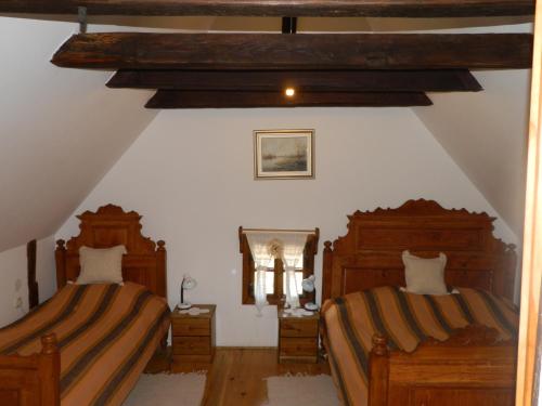 a attic bedroom with two beds and a mirror at Tradicije Cigoc in Čigoč