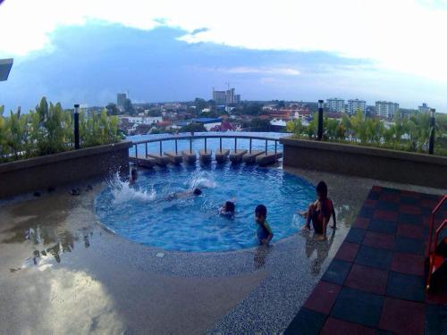 a group of people playing in a swimming pool at Julia's Cottage in Kota Bharu