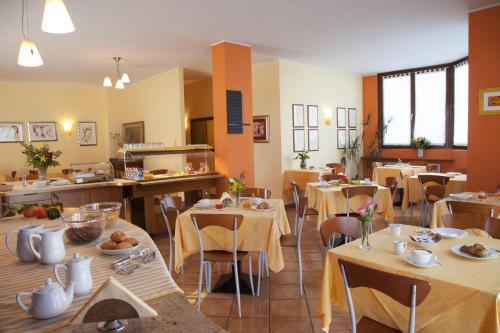 um restaurante com mesas e cadeiras e uma cafetaria em Hotel Naonis em Cordenons
