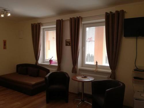 a living room with a couch and two windows at Vila Mária Rapovce in Rapovce