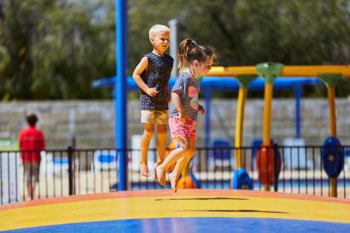 
a girl and a boy playing in a pool at BIG4 Breeze Holiday Parks - Busselton in Busselton
