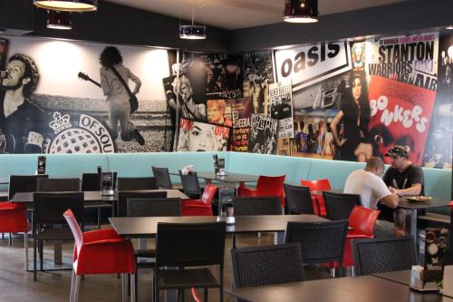 a restaurant with tables and chairs and posters on the walls at The Jack Backpackers in Cairns