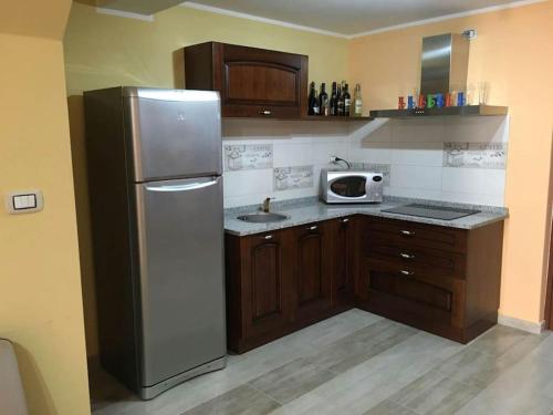 una cucina con frigorifero in acciaio inox e forno a microonde di Casa Il Nuraghe a Monserrato