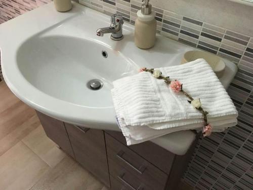 un lavandino in bagno con un asciugamano bianco di Casa Il Nuraghe a Monserrato