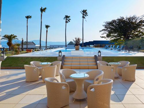 a patio with tables and chairs and a pool at Infinito Hotel and Spa in Shirahama
