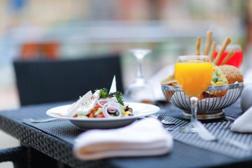 a table with a plate of food and a glass of orange juice at Tolip Family Park Hotel in Cairo
