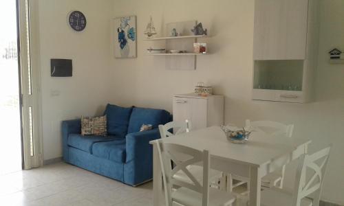トッレ・スーダにあるSalento SeaHouseのリビングルーム(青いソファ、テーブル付)