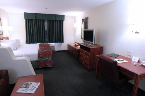 a hotel room with a bed and a television at Garden Place Suites in Sierra Vista