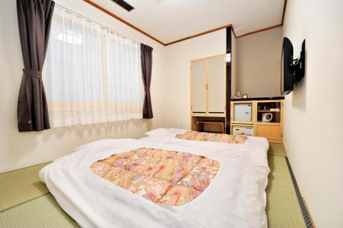 Hotel Paco Obihiro Ekimae في أوبيهيرو: غرفة نوم بسريرين ونافذة
