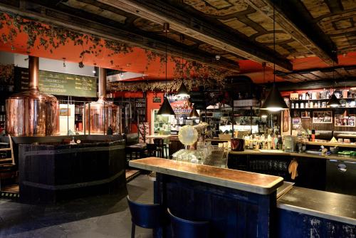 un bar avec un comptoir et des chaises dans un restaurant dans l'établissement Gaststätte Brauhaus Zwickau GmbH, à Zwickau