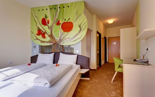 ein Schlafzimmer mit einem Bett und einem Gemälde an der Wand in der Unterkunft Pension Sonnengarten & Therme included - auch am An- & Abreisetag! in Lutzmannsburg