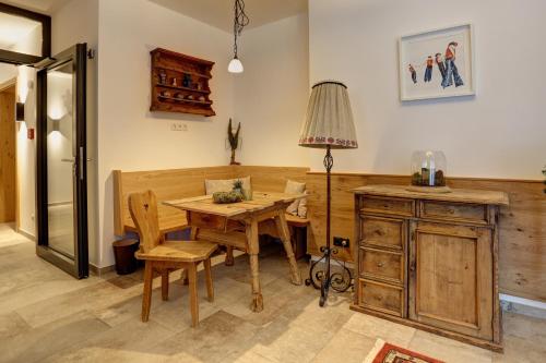 a dining room with a wooden table and a lamp at Kösslerhof in Sankt Anton am Arlberg