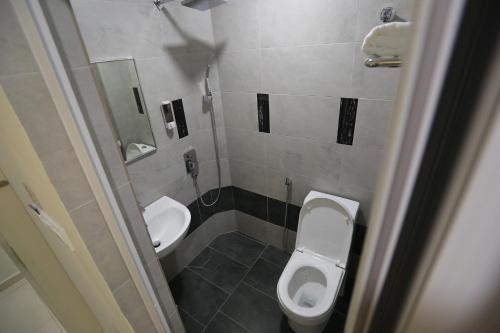 a small bathroom with a toilet and a sink at Pantai Regal Boutique Hotel in Kuantan